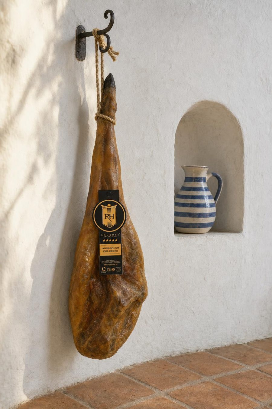 Jamón ibérico RH Gourmet colgado junto a una hornacina encalada